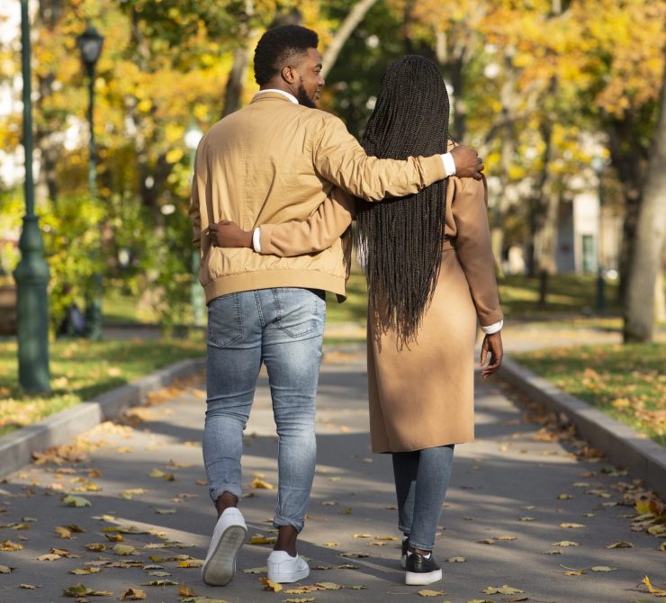 Rear view of couple in love walking in autumn park Romantic walk. Rear view of couple in love walking in autumn park and embracing each other, panorama