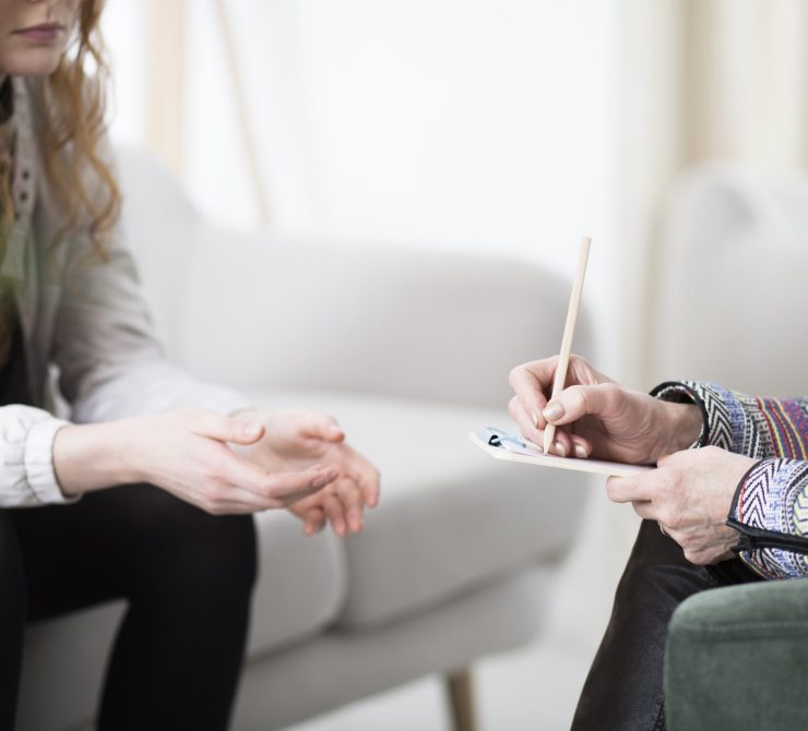Therapist writing down notes Cropped photo of a therapist writing down notes during therapy with her female patient